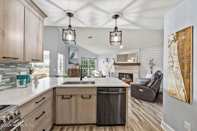 kitchen with decorative light fixtures, a fireplace, stainless steel appliances, sink, and lofted ceiling