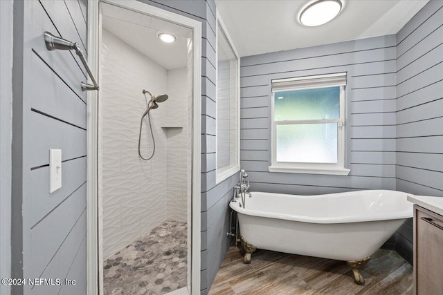 bathroom featuring vanity, wood-type flooring, independent shower and bath, and wood walls