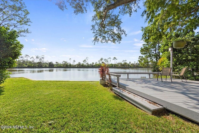 dock area with a water view and a lawn