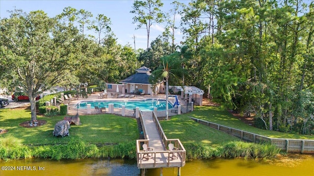 exterior space with a water view, a lawn, and a fenced in pool