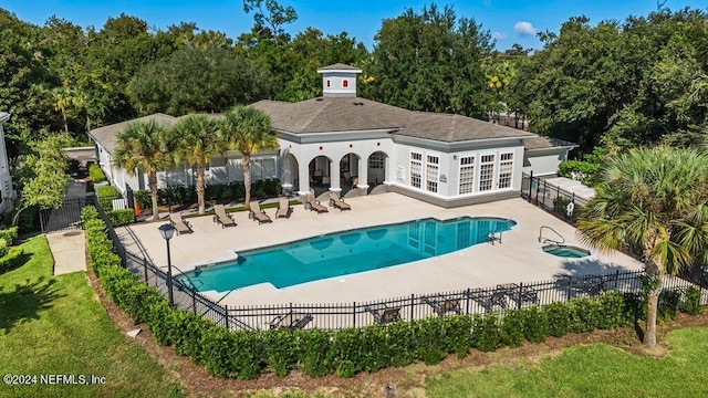 back of property with french doors, a fenced in pool, and a patio area