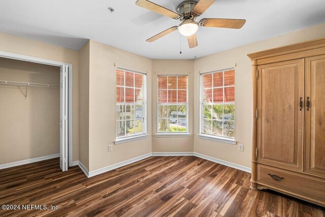 unfurnished bedroom with dark hardwood / wood-style flooring, ceiling fan, and a closet