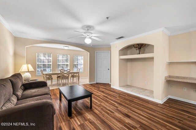 living room featuring ceiling fan, crown molding, and dark wood-type flooring