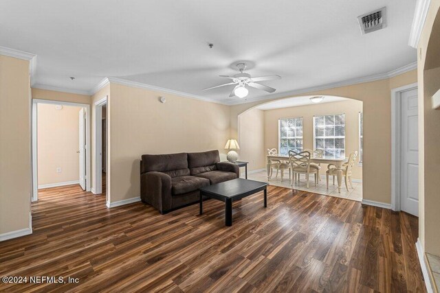 living room featuring crown molding, dark wood-type flooring, and ceiling fan