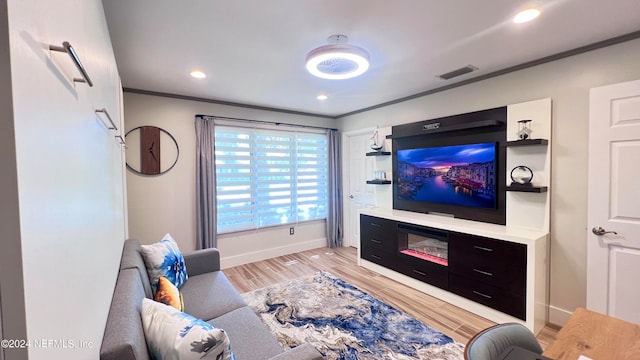 living room featuring crown molding and light hardwood / wood-style flooring