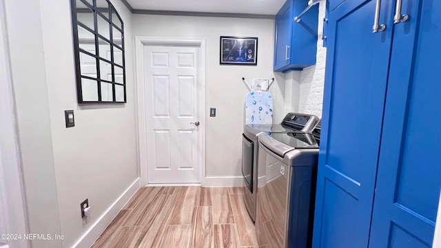 washroom featuring light wood-type flooring, crown molding, separate washer and dryer, and cabinets