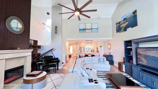 living room with light parquet floors, ceiling fan, a premium fireplace, and high vaulted ceiling