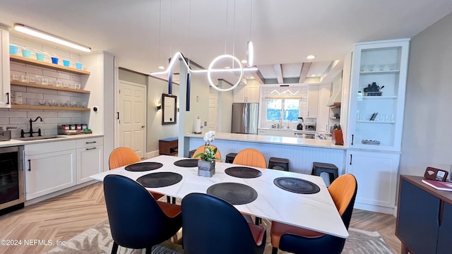 dining space with light parquet floors, sink, and beverage cooler