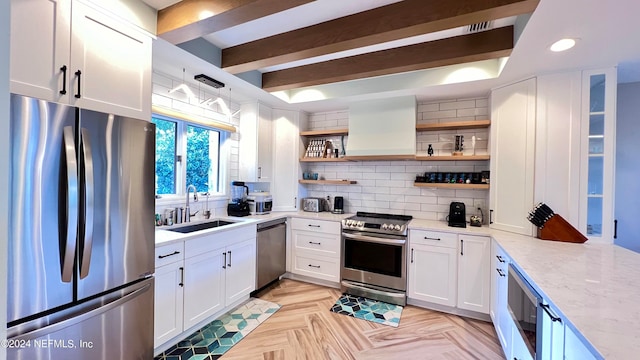 kitchen with appliances with stainless steel finishes, custom range hood, white cabinetry, tasteful backsplash, and light stone countertops