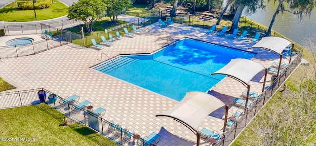 view of pool with a yard, a patio, a community hot tub, and a water view