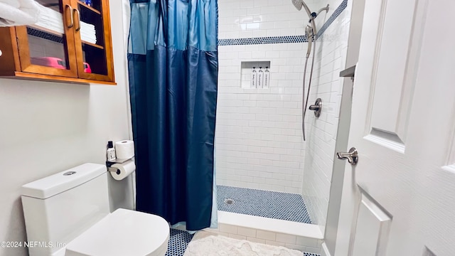 bathroom featuring toilet and curtained shower