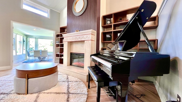 misc room featuring wood-type flooring, vaulted ceiling, and a high end fireplace