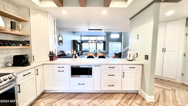 kitchen featuring decorative backsplash, white cabinetry, and appliances with stainless steel finishes