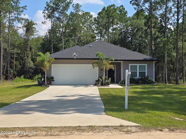 single story home featuring an attached garage, a shingled roof, concrete driveway, and a front yard