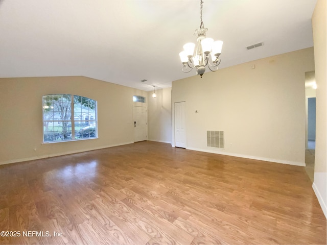 spare room featuring light wood-style floors, visible vents, baseboards, and a notable chandelier