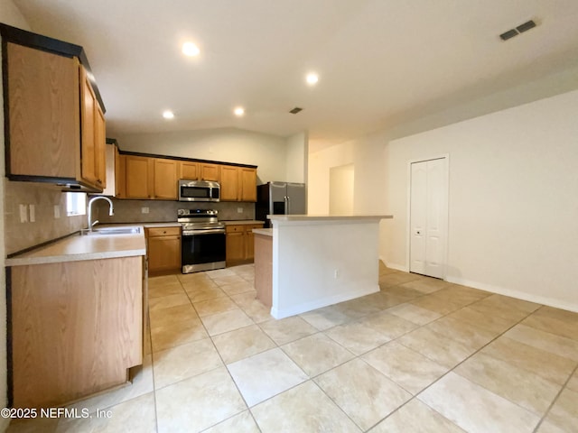 kitchen featuring visible vents, lofted ceiling, a sink, light countertops, and appliances with stainless steel finishes