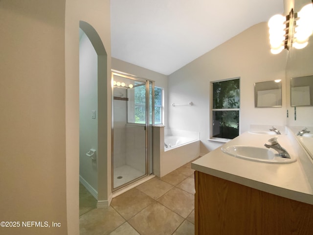 full bathroom with tile patterned flooring, a garden tub, vaulted ceiling, a stall shower, and a sink