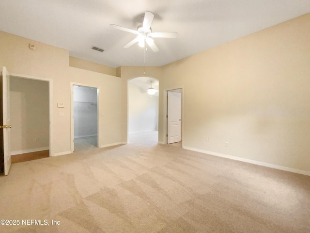 unfurnished bedroom with a spacious closet, a closet, light carpet, and baseboards