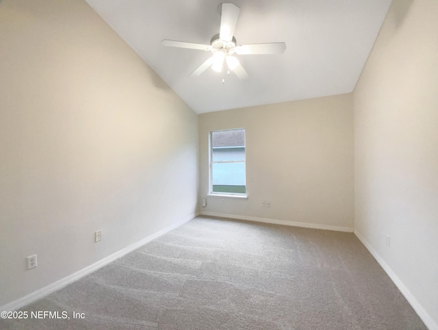 empty room featuring carpet floors, a ceiling fan, baseboards, and vaulted ceiling