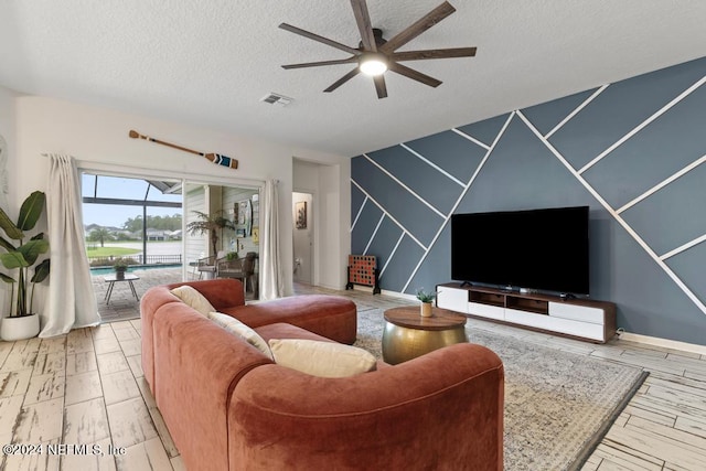 living room featuring a textured ceiling and ceiling fan