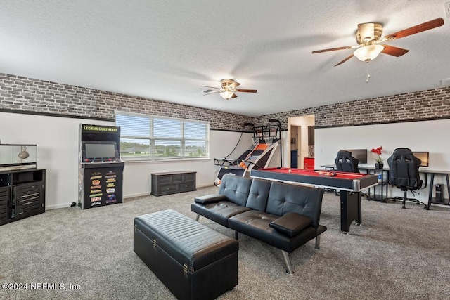 game room with a textured ceiling, brick wall, ceiling fan, and carpet floors