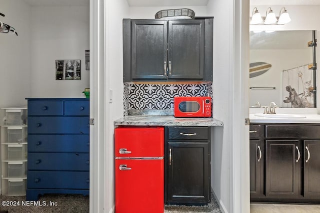 bar featuring tasteful backsplash and sink