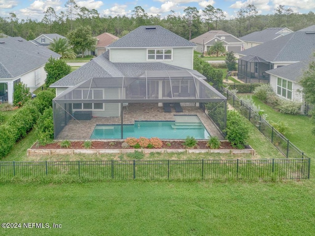 exterior space with glass enclosure, a fenced in pool, a yard, and a patio area