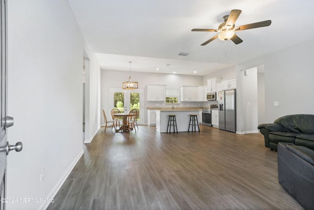 living room with ceiling fan and dark wood-type flooring