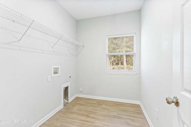 washroom featuring washer hookup, gas dryer hookup, light hardwood / wood-style floors, and electric dryer hookup