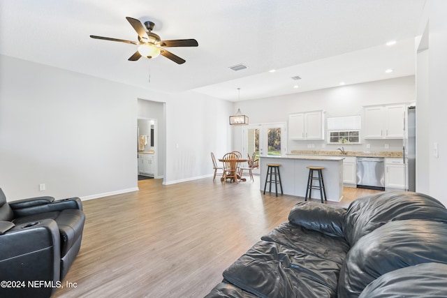 living room featuring ceiling fan and light hardwood / wood-style flooring