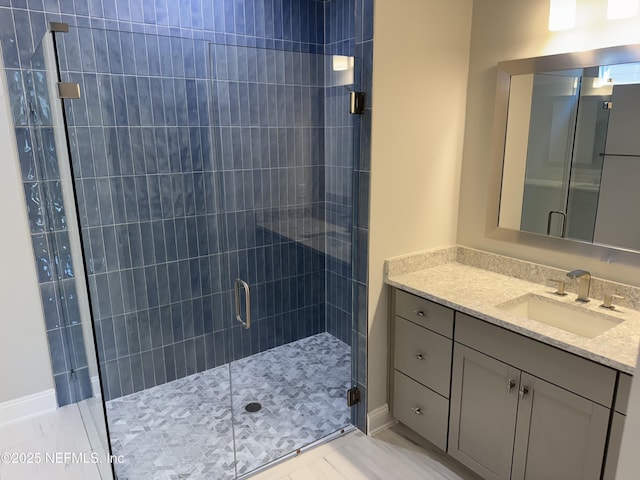 bathroom with a shower with door and vanity