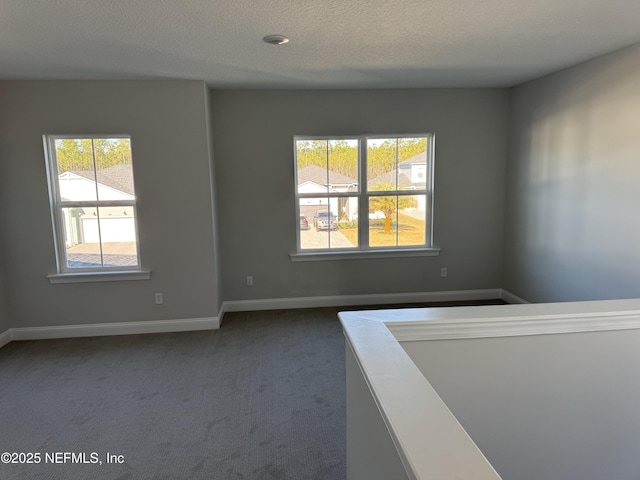 carpeted spare room with a textured ceiling