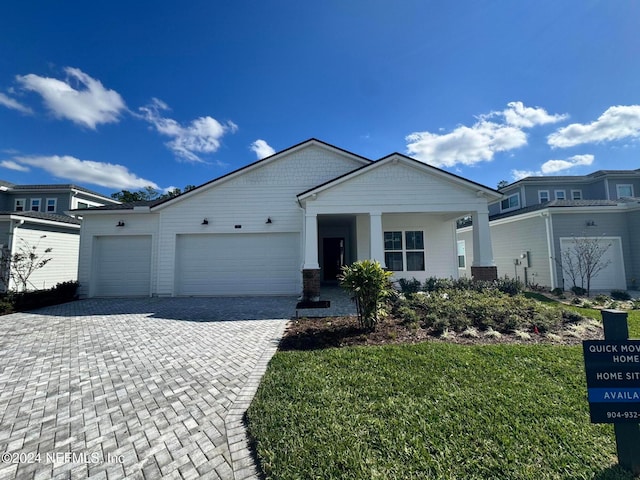 view of front of home featuring a garage and a front lawn