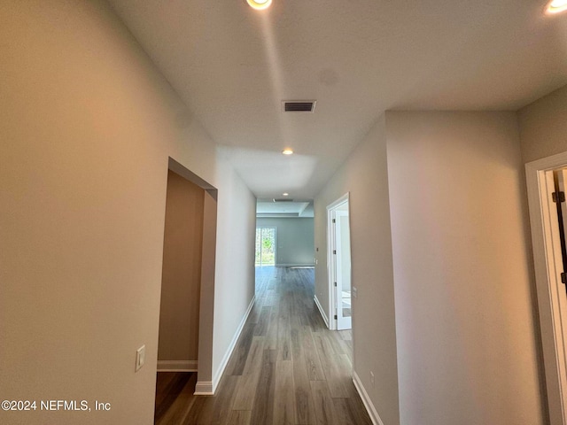 corridor with hardwood / wood-style flooring