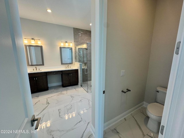 bathroom featuring vanity, a shower with door, and toilet