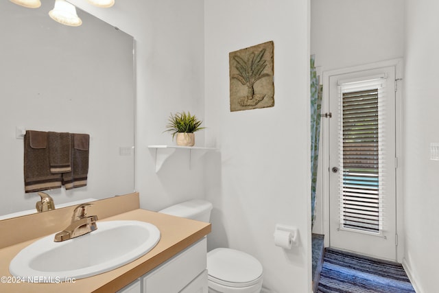 bathroom with vanity, toilet, and wood-type flooring