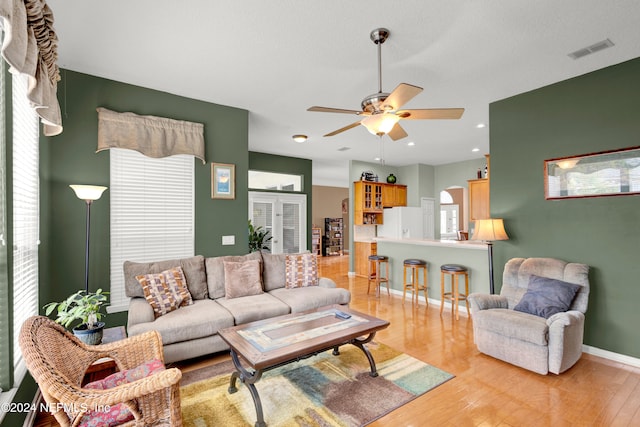 living room with ceiling fan, a wealth of natural light, and light hardwood / wood-style floors