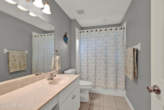 full bathroom featuring tile patterned flooring, vanity, toilet, and shower / tub combo with curtain