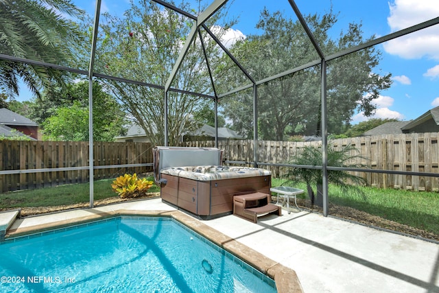 view of pool featuring a lanai, a hot tub, and a patio area