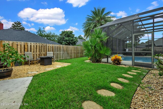 view of yard with a fenced in pool and glass enclosure