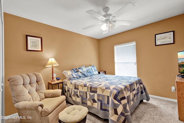 bedroom featuring ceiling fan, light colored carpet, and a textured ceiling