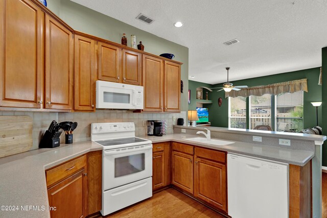 kitchen featuring kitchen peninsula, white appliances, ceiling fan, and light hardwood / wood-style floors