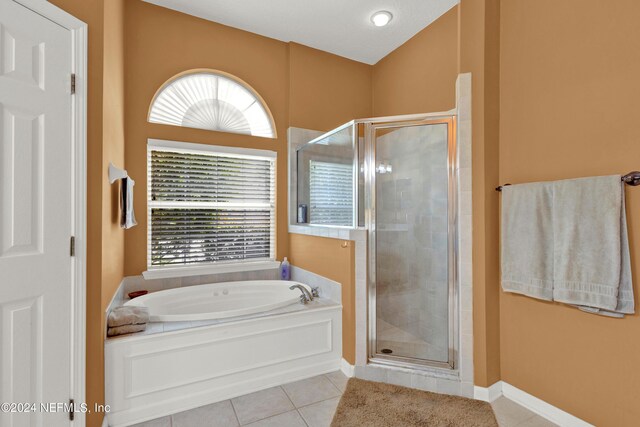 bathroom with separate shower and tub and tile patterned flooring