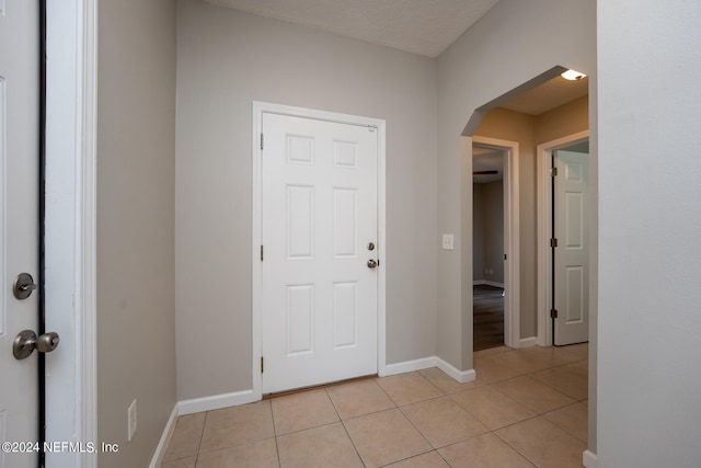 hallway featuring a textured ceiling and light tile patterned floors