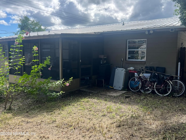 rear view of property featuring a sunroom