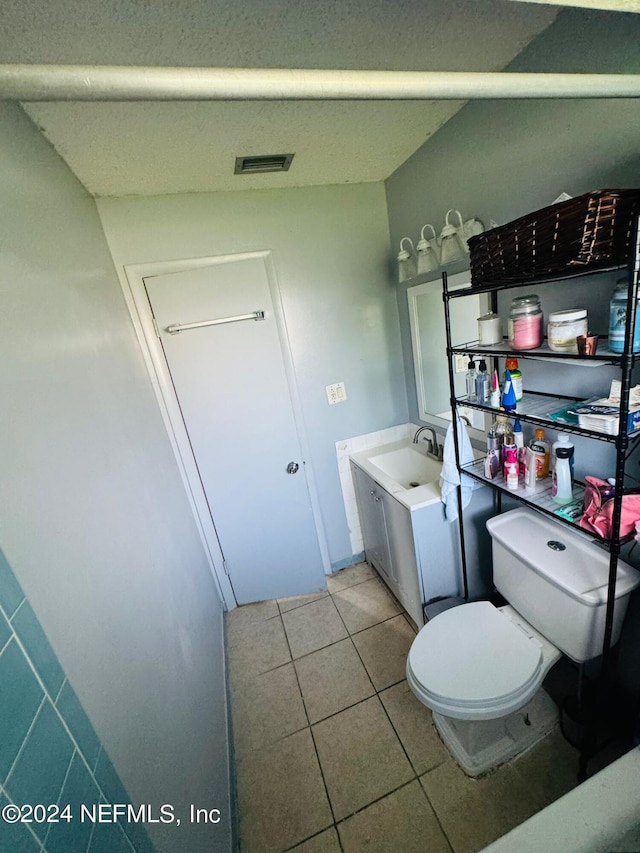 bathroom featuring tile patterned flooring, vanity, and toilet