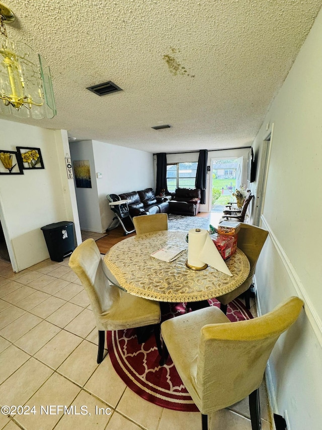 tiled dining space with a textured ceiling