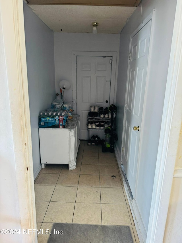 hall featuring light tile patterned floors