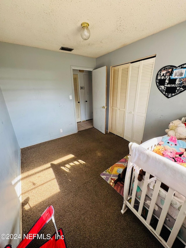 bedroom featuring carpet, a closet, and a textured ceiling