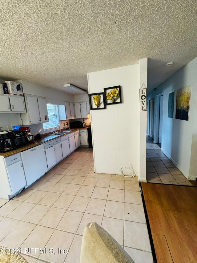 kitchen with a textured ceiling, sink, and light tile patterned flooring